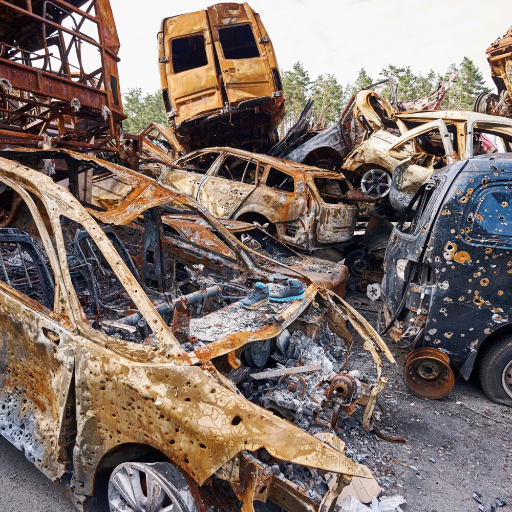 Civilian vehicles with bullet holes lying on junkyard