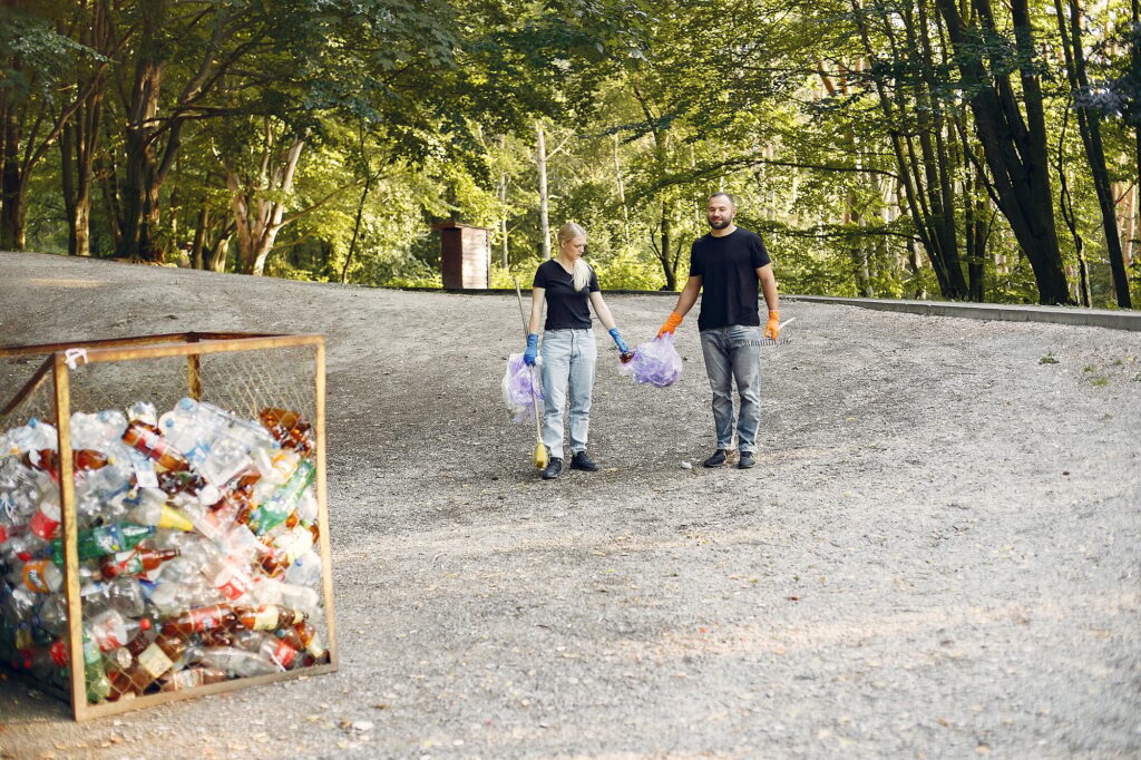 Couple collects garbage in garbage bags in park
